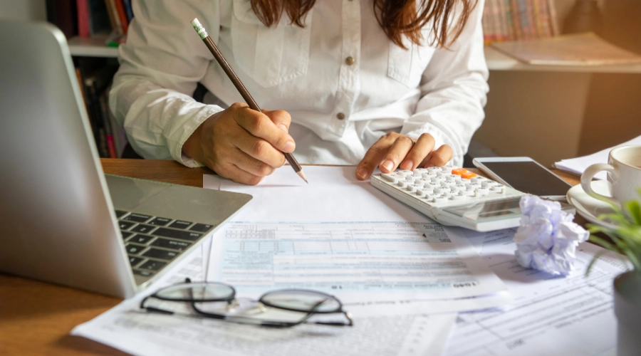person writing budget on paper