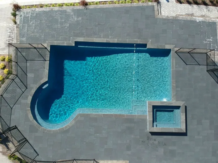 Aerial view of a geometric in-ground pool with attached square spa and large bluestone patio surround in New Jersey by Gorlin Pools