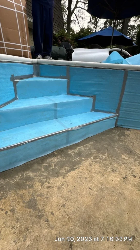 Blue foam insulation board taped over pool steps and walls in a drained pool during vinyl liner replacement preparation in Lakehurst, NJ by Gorlin Pools