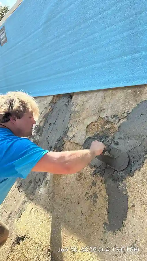 Gorlin Pools technician applying mortar to repair a cracked pool wall before vinyl liner installation in Lakehurst, NJ