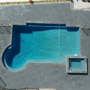 Aerial view of a geometric in-ground pool with attached square spa and large bluestone patio surround in New Jersey by Gorlin Pools