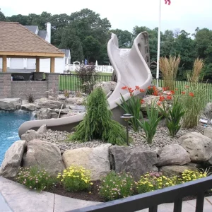 Custom inground pool with natural rock waterfall and slide installed by Gorlin Pools and Spas in Lakehurst NJ