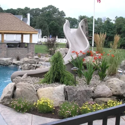 Custom inground pool with natural rock waterfall and slide installed by Gorlin Pools and Spas in Lakehurst NJ