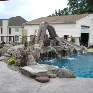 freeform-pool-gray-curved-slide-stepped-rock-waterfall-stamped-concrete-suburban-lakehurst-nj-gorlin-pools