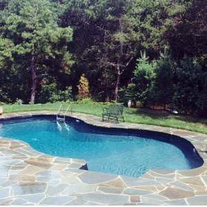 Freeform vinyl liner pool with flagstone patio deck installed by Gorlin Pools and Spas in Lakehurst NJ