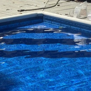 Close-up of pool entry steps with a newly installed patterned vinyl liner being filled with water in New Jersey by Gorlin Pools